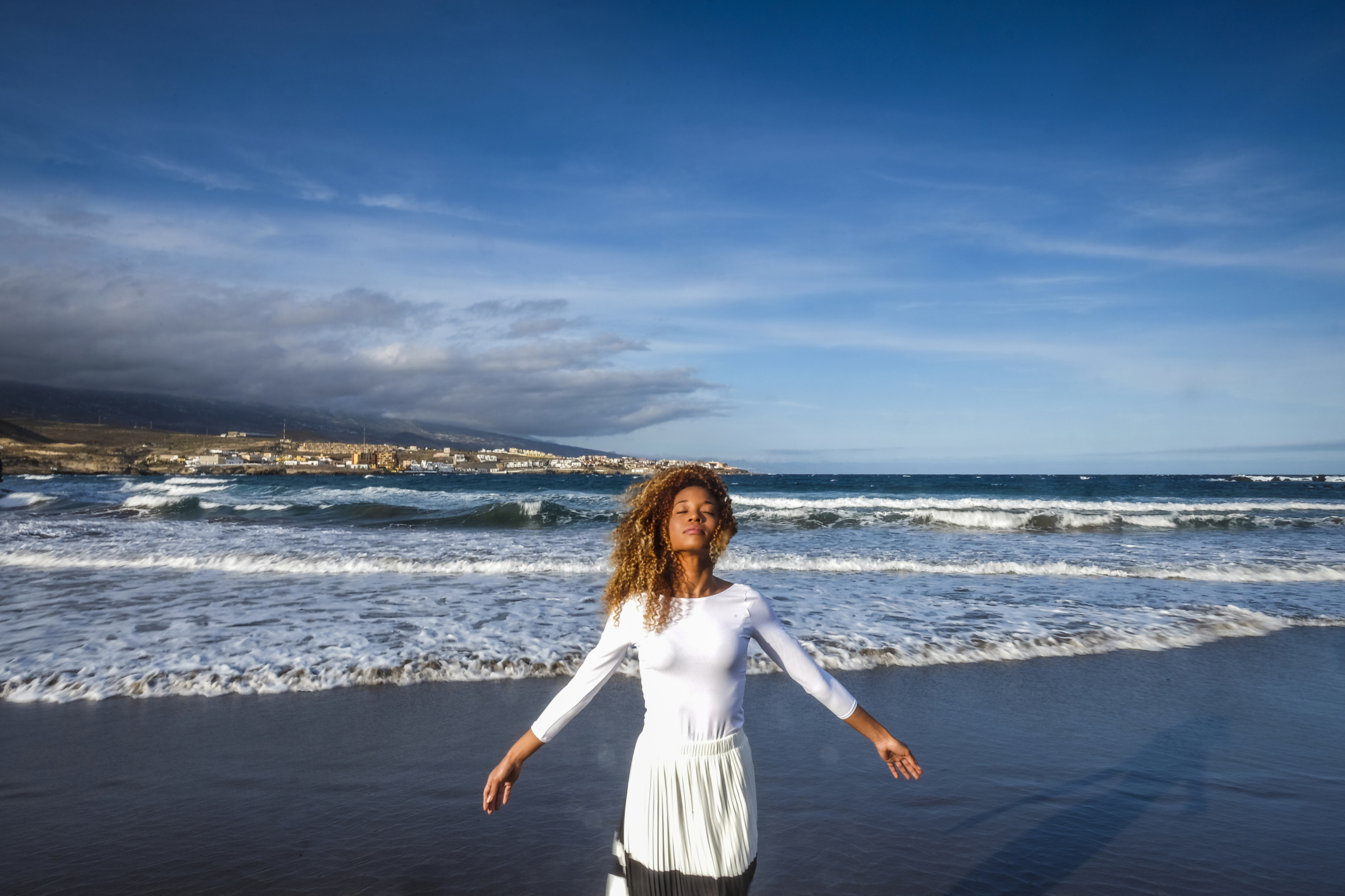 Spain, Tenerife, woman with closed eyes standing on the beach