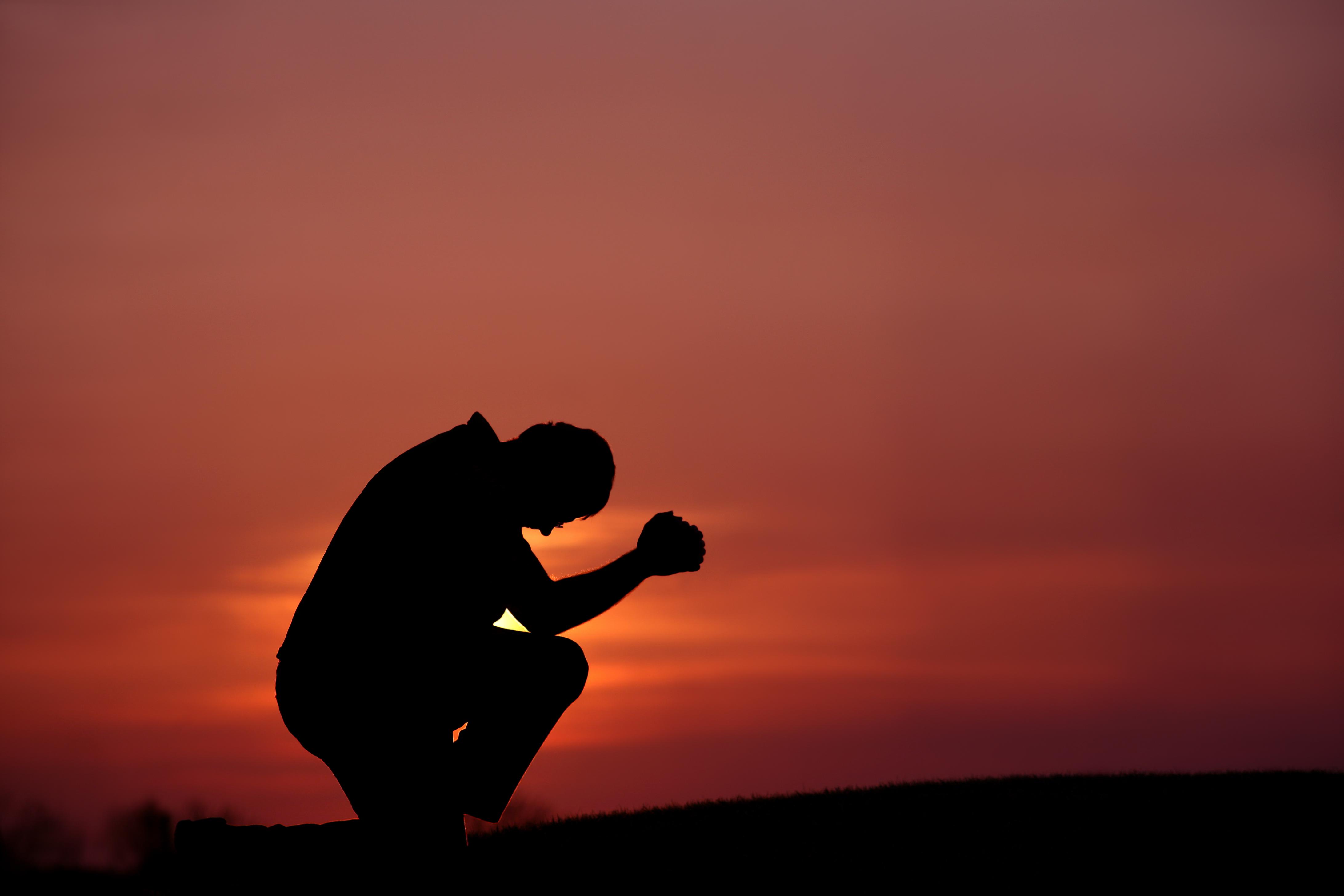 Silhouette of Man Praying at Dusk