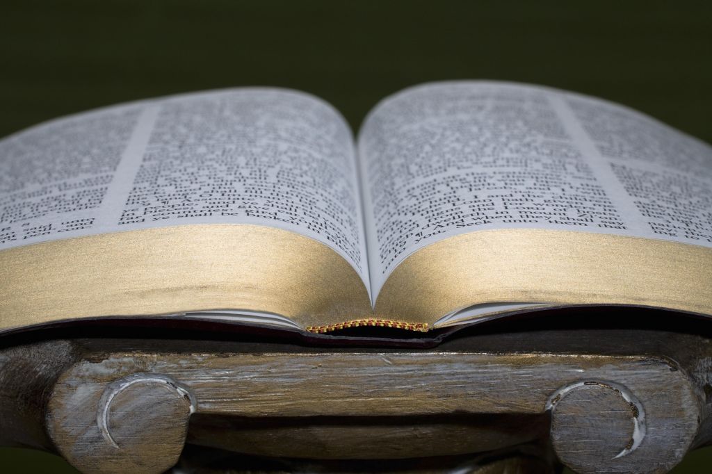 An open Bible on a pedestal
