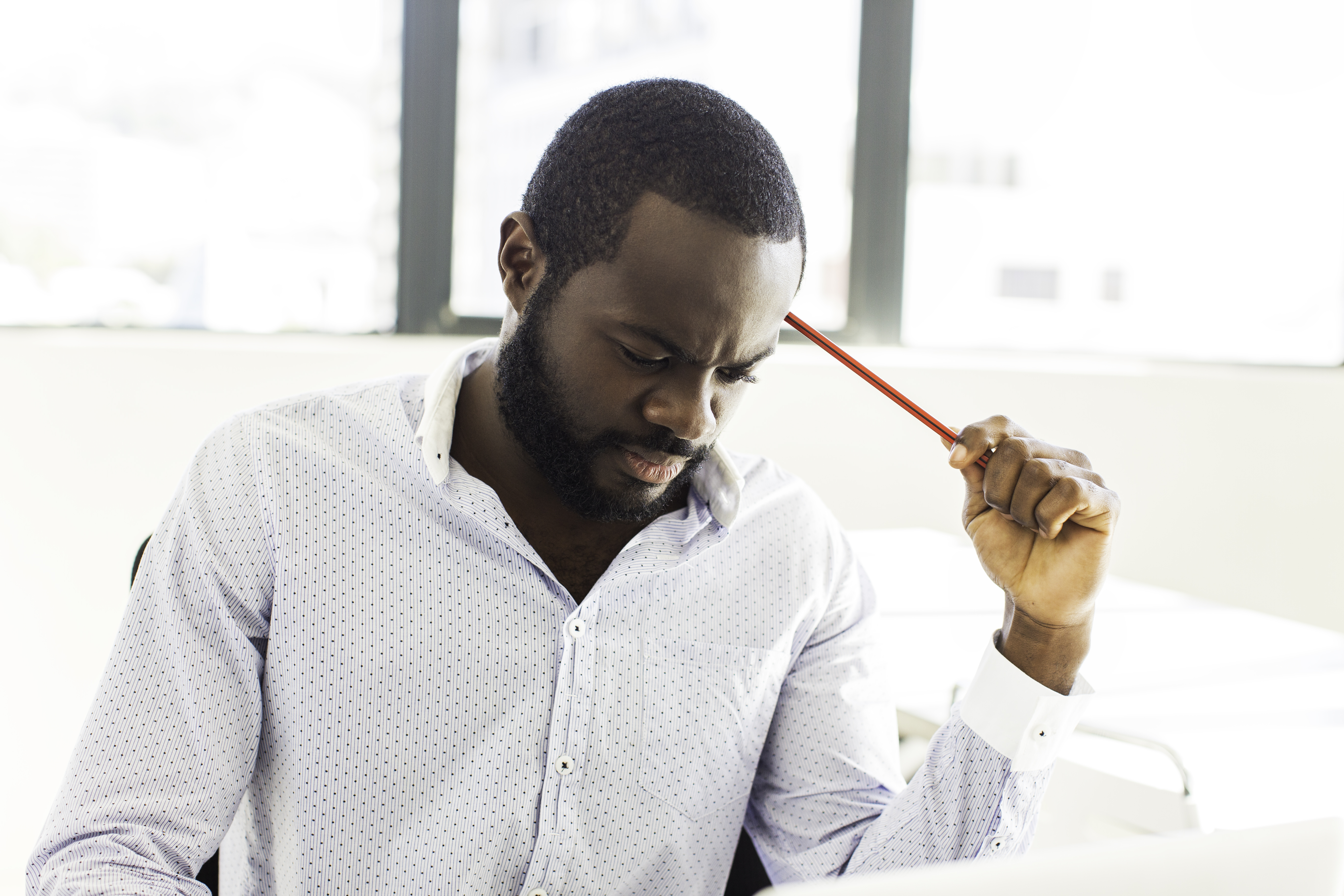 African businessman thinking hard.
