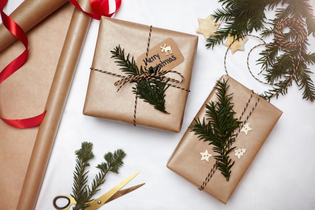 Christmas gifts wrapped in brown paper, decorated with fern and string, overhead view