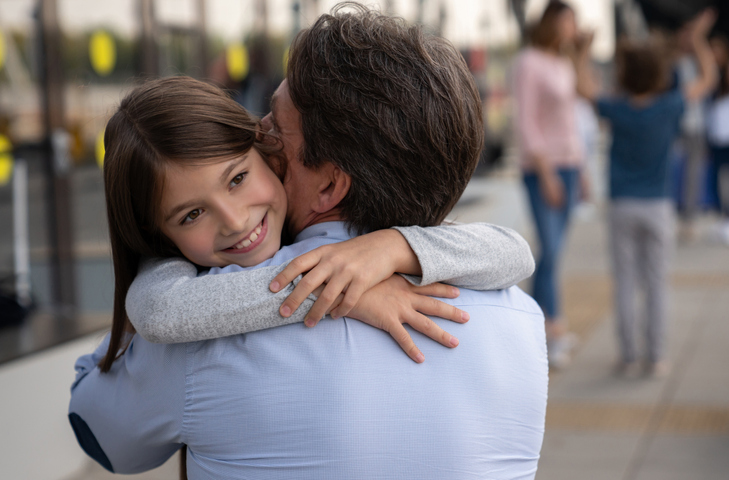 Daughter hugging her father at the airport