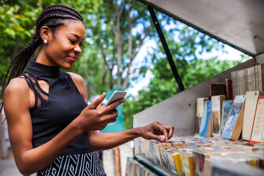 Young woman looking for books in a kiosk in Paris