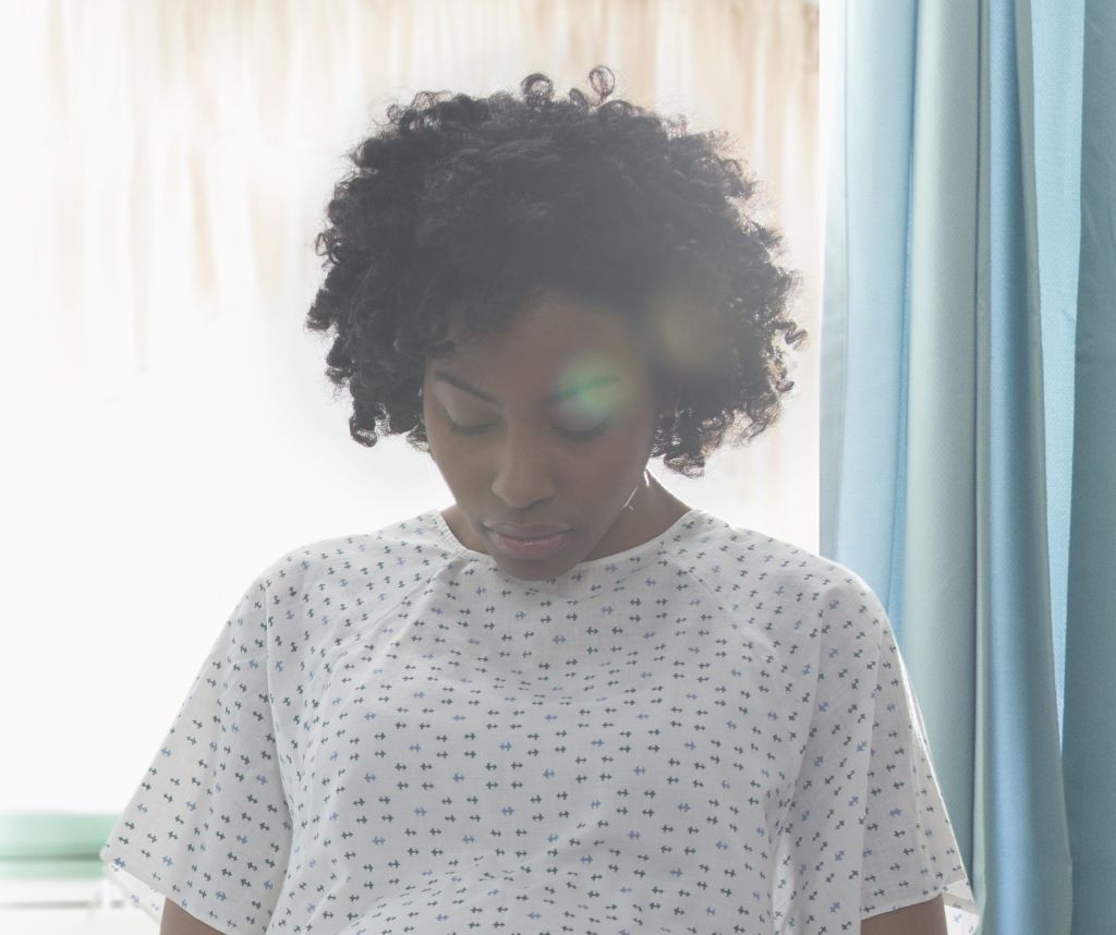 Pregnant African American woman holding her stomach in hospital