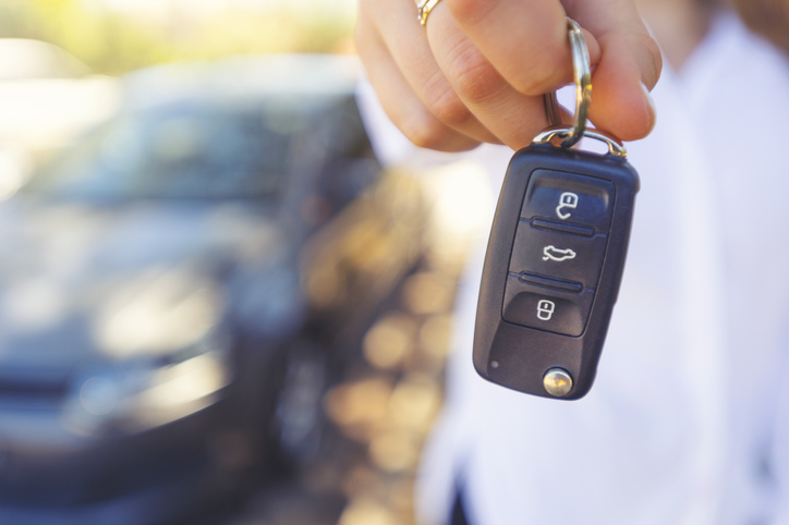 Female car salesperson handing over the new car keys